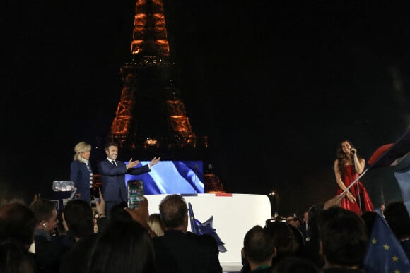 Le président français Emmanuel Macron et sa femme Brigitte Macron célèbrent la victoire du second tour de l'élection présidentielle française au Champ de Mars devant la Tour Eiffel, à Paris, France, 24 avril 2022. Ils applaudissent la performance de la cantatrice Farrah El Dibany