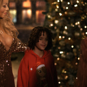 Images de la vidéo spéciale Noël de Mariah Carey. Elle porte une robe Dolce and Gabbana à perles dorées aux dires de la chanteuse "pesait entre 60 et 70 livres".