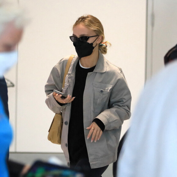 Exclusif - Lily-Rose Depp, escortée par un garde du corps, arrive à l'aéroport de Los Angeles, après avoir fêté son 23 ème anniversaire. Dans le même temps, son père J.Depp attend le verdict dans son procès en diffamation contre son ex-femme, A.Heard. Le 31 mai 2022.