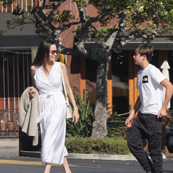 Angelina Jolie et son fils Knox font des provisions chez "Gelson's" à Los Angeles, le 15 août 2022. Knox porte les courses de sa mère jusqu'à leur voiture.