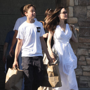 Angelina Jolie et son fils Knox font des provisions chez "Gelson's" à Los Angeles, le 15 août 2022. Knox porte les courses de sa mère jusqu'à leur voiture. 