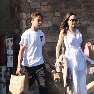 Angelina Jolie et son fils Knox font des provisions chez "Gelson's" à Los Angeles, le 15 août 2022. Knox porte les courses de sa mère jusqu'à leur voiture.