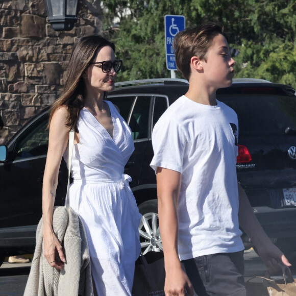 Angelina Jolie et son fils Knox font des provisions chez "Gelson's" à Los Angeles, le 15 août 2022. Knox porte les courses de sa mère jusqu'à leur voiture.