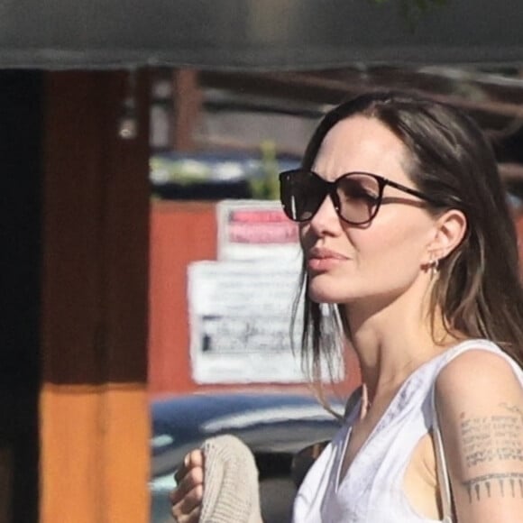 Angelina Jolie et son fils Knox font des provisions chez "Gelson's" à Los Angeles, le 15 août 2022. Knox porte les courses de sa mère jusqu'à leur voiture.