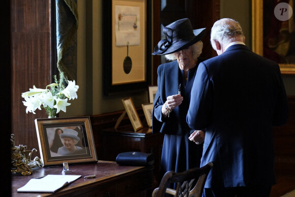 Camilla Parker Bowles, reine consort d'Angleterre, examine le stylo défectueux avec lequel le roi Charles III a signé le livre d'or au Hillsborough Castle le 13 septembre 2022.