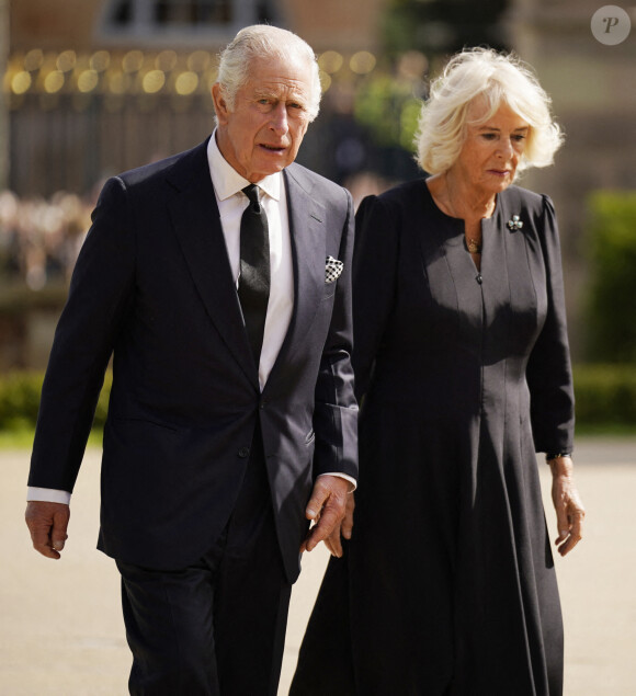 Le roi Charles III d'Angleterre et Camilla Parker Bowles, reine consort d'Angleterre, saluent la foule aux abords du château de Hillsborough à Belfast, le 13 septembre 2022.