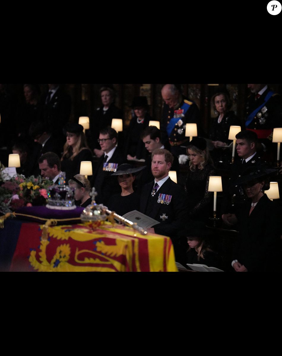Lena Tindall, Zara Tindall, Mia Tindall, Le prince Harry, duc de Sussex et Meghan Markle, duchesse de Sussex, Princesse Charlotte, Catherine (Kate) Middleton, princesse de Galles, Prince George, Le prince William, prince de Galles - Cérémonie funèbre en La Chapelle Saint-Georges en présence des 15 Premiers ministres des royaumes qui ont exercé pendant les 70 ans de règne de la reine Elizabeth II d'Angleterre. Le cercueil sera descendu dans la crypte royale de la Chapelle Saint-Georges où elle reposera au côté de son époux le prince Philip, décédé le 9 avril 2021. Une cérémonie privée d'inhumation se tiendra au Mémorial du roi George VI. Windsor, le 19 septembre 2022. © Victoria Jones / Bestimage Members of the royal family (front row, left to right) Lena Tindall, Zara Tindall, Mia Tindall, the Duchess of Sussex, the Duke of Sussex, Princess Charlotte, the Princess of Wales, Prince George, and the Prince of Wales, stand for the coffin of Queen Elizabeth II, draped in the Royal Standard with the Imperial State Crown and the Sovereign's orb and sceptre, during the Committal Service at St George's Chapel in Windsor Castle, Berkshire. Picture date: Monday September 19, 2022.