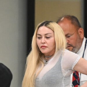 Madonna et son fils David Banda, 16 ans, arrivent à l'aéroport JFK à New York, le 11 août 2022. Au moment de passer le contrôle avant d'embarquer, la chanteuse de 63 ans laisse apparaître son tee-shirt en résille transparent.