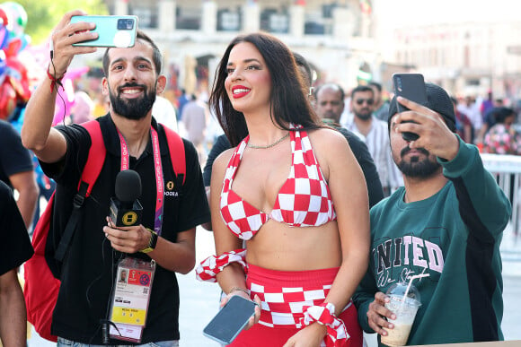 Ivana Knöll, la sulfureuse supportrice croate pose avec ses fans à Doha lors du Mondial 2022 au Qatar le 11 décembre 2022. La jeune supportrice croate assiste à toutes les rencontres de son pays et est reconnue dans tous les stades. Même en dehors dans les rues de Doha, elle ne passe plus inaperçue. Ivana Knöll est en train de devenir une star au Qatar. La mannequin croate de 30 ans possède désormais une très grande communauté. Alors qu'elle possédait moins d'un million d'abonnés sur son compte Instagram, avant le début du Mondial, elle est suivie par plus de 2,3 millions de personnes.