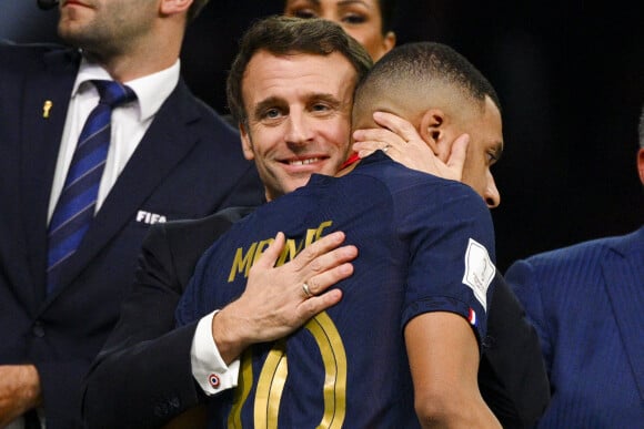 Kylian Mbappé accolade avec Emmanuel Macron - president de la Republique Francaise - Remise du trophée de la Coupe du Monde 2022 au Qatar (FIFA World Cup Qatar 2022) à l'équipe d'argentine après sa victoire contre la France en finale (3-3 - tab 2-4). Doha, le 18 décembre 2022.