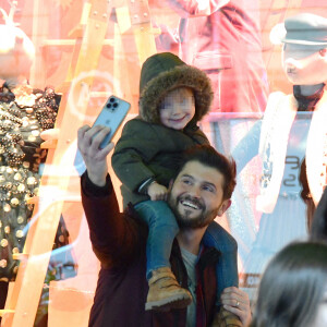 Exclusif - Christophe Beaugrand emmène son fils Valentin (3 ans) découvrir les vitrines de Noël des Grand Magasins à Paris le 19 décembre 2022.