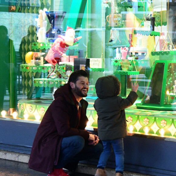 Exclusif - Christophe Beaugrand emmène son fils Valentin (3 ans) découvrir les vitrines de Noël des Grand Magasins à Paris le 19 décembre 2022.