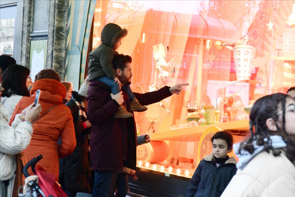 Exclusif - Christophe Beaugrand emmène son fils Valentin (3 ans) découvrir les vitrines de Noël des Grand Magasins à Paris le 19 décembre 2022.