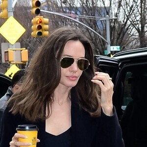 Angelina Jolie se dirige vers un centre d'art à New York City, New York, Etats-Unis avec un café à emporté de chez Carlyle. L'actrice américaine portait une tenue entièrement noire avec un grand sac matelassé YSL. 