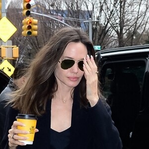 Angelina Jolie se dirige vers un centre d'art à New York City, New York, Etats-Unis, le 12 janvier 2023, avec un café à emporté de chez Carlyle. L'actrice américaine portait une tenue entièrement noire avec un grand sac matelassé YSL. 