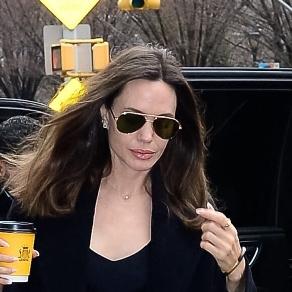 Angelina Jolie se dirige vers un centre d'art à New York City, New York, Etats-Unis, le 12 janvier 2023, avec un café à emporté de chez Carlyle. L'actrice américaine portait une tenue entièrement noire avec un grand sac matelassé YSL. 