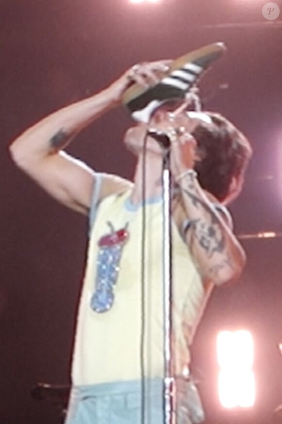 Harry Styles boit de l'alcool dans sa chaussure lors de son concert à Perth (Australie), le 20 février 2023. 