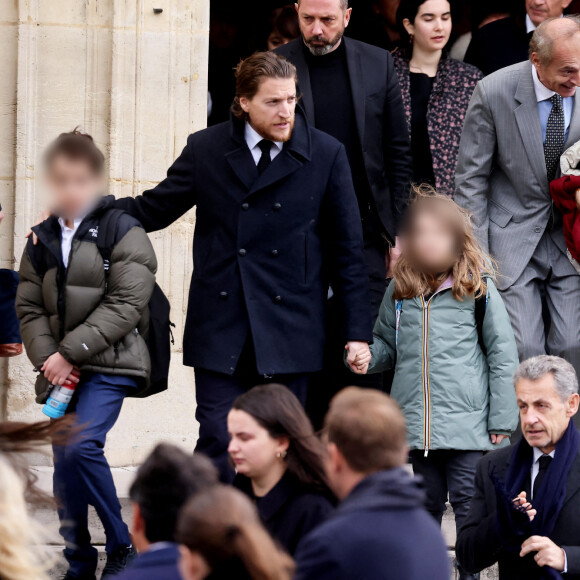 Des clichés sur lesquels on peut également observer qu'en plus d'êtres parés de manteaux bien chauds, ils avaient des sac à dos sur leurs épaules, ce qu'il laisse supposer qu'ils allaient se rendre à leur école immédiatement après les obsèques, ou bien qu'ils en revenaient. 
Nicolas Sarkozy et sa femme Carla Bruni Sarkozy, Jean Sarkozy et ses enfants - Sorties des obsèques de Päl Sarkozy de Nagy Bocsa, le père de Nicolas Sarkozy, en l'église Saint-Jean Baptiste à Neuilly sur Seine le 9 mars 2023. © Dominique Jacovides / Bestimage 