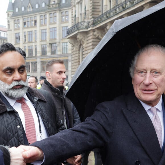 La blague a fait son petit effet malgré la pluie. Charles a décliné mais a bien rigolé !
Bain de foule pour le roi Charles III d'Angleterre à Hambourg, le 31 mars 2023. Après l'annulation de leur visite en France, en raison des manifestation contre la réforme des retraites, le roi Charles et la reine consort sont en voyage officiel en Allemagne jusqu'au 31 mars 2023. 