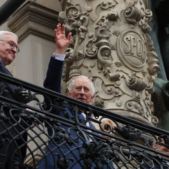 Le roi Charles III d'Angleterre salue la foule depuis le balcon de la mairie à Hambourg, le 31 mars 2023, sous le regard du président allemand, F-W.Steinmeier. Après l'annulation de leur visite en France, en raison des manifestation contre la réforme des retraites, le roi Charles et la reine consort sont en voyage officiel en Allemagne jusqu'au 31 mars 2023. 