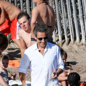 Intégré au sein de sa belle-famille, il décrit le domaine comme un lieu chaleureux gérée par des femmes puissantes
Exclusif - Nicolas Sarkozy, sa femme Carla Bruni-Sarkozy et leur fille Giulia sont sur la plage de Cavalières au pied du Cap Nègre, le 14 juillet 2014, pendant leurs vacances.