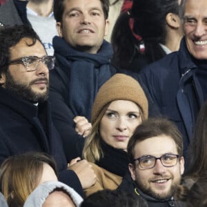 Pas sûr, en revanche, qu'elle l'invite un jour pour l'interroger à propos de sa musique.
Maxim Nucci (Yodelice) et sa compagne Isabelle Ithurburu dans les tribunes lors du match de rugby du Tournoi des 6 Nations opposant la France à l'Angleterre au stade de France, à Saint-Denis, Seine Saint-Denis, le 19 mars 2022. © Cyril Moreau/Bestimage