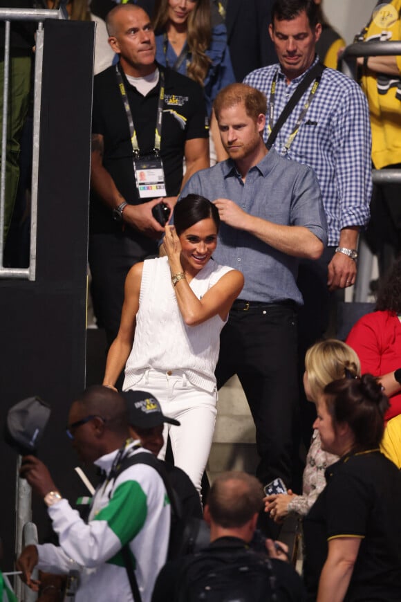 Le prince Harry, duc de Sussex et Meghan Markle, duchesse de Sussex, acclament l'équipe mixte Ukraine Nigeria lors du match de volley-ball au quatrième jour des Invictus Games à Dusseldorf, le 14 septembre 2023. 