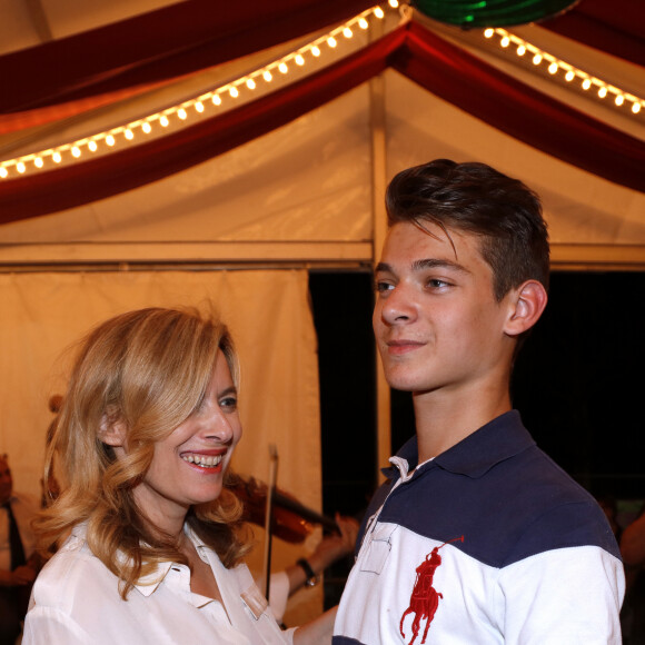 Valérie Trierweiler et son fils Léonard dansent lors de l'inauguration de la Fête des Tuileries à Paris le 26 juin 2015.