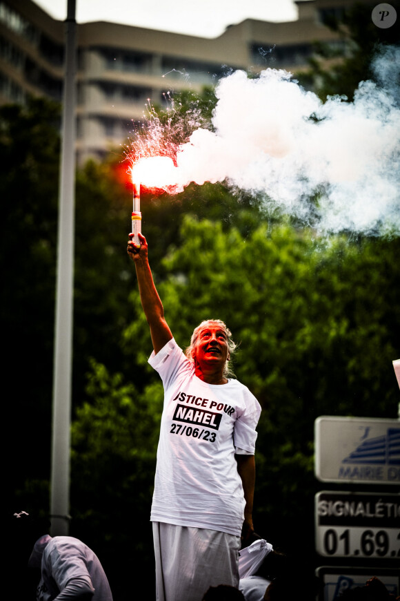 Mounia, la mère de Nahel porte un fumigène en ouverture de cortège sur le camion lors de la marche blanche organisée en hommage à Nahel jeune homme tué par un policier après un refus d'obtempérer, à Nanterre, France, le 29 juin 2023. 6 200 personnes sont présentes, selon la police. © Jean-Baptiste Autissier/Panoramic/bestimage 