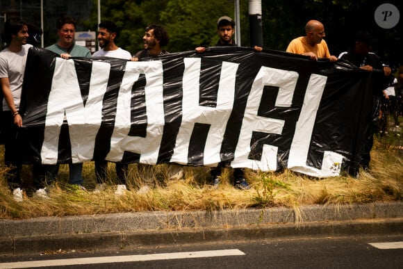 Il est placé sous contrôle judiciaire, doit "verser un cautionnement" et a interdiction d'entrer en contact avec les parties civiles, "de paraître à Nanterre" et de "détenir une arme"
Marche blanche organisée en hommage à Nahel jeune homme tué par un policier après un refus d'obtempérer, à Nanterre, France, le 29 juin 2023. 6 200 personnes sont présentes, selon la police. © Jean-Baptiste Autissier/Panoramic/bestimage 