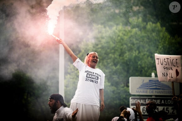 Mounia, la mère de Nahel porte un fumigène en ouverture de cortège sur le camion lors de la marche blanche organisée en hommage à Nahel jeune homme tué par un policier après un refus d'obtempérer, à Nanterre, France, le 29 juin 2023. 6 200 personnes sont présentes, selon la police. © Jean-Baptiste Autissier/Panoramic/bestimage 