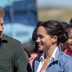 Le prince Harry, duc de Sussex, et Meghan Markle, duchesse de Sussex rencontrent les membres de "Waves for Change" un organisme de bienfaisance qui travaille avec les surfeurs locaux sur la plage de Monwabisi au Cap lors de leur 2ème journée en Afrique du Sud, le 24 septembre 2019. 