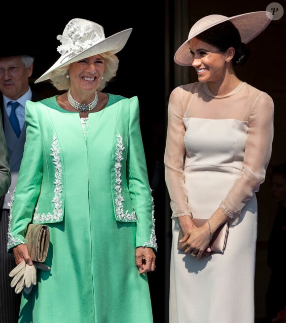 Dans son livre "Spare", le prince Harry n'a pas été des plus tendres avec Camilla. Le duc de Sussex y a ainsi qualifié sa belle-mère de "dangereuse" et "méchante".
Camilla Parker Bowles, duchesse de Cornouailles, Meghan Markle, duchesse de Sussex lors de la garden party pour les 70 ans du prince Charles au palais de Buckingham à Londres