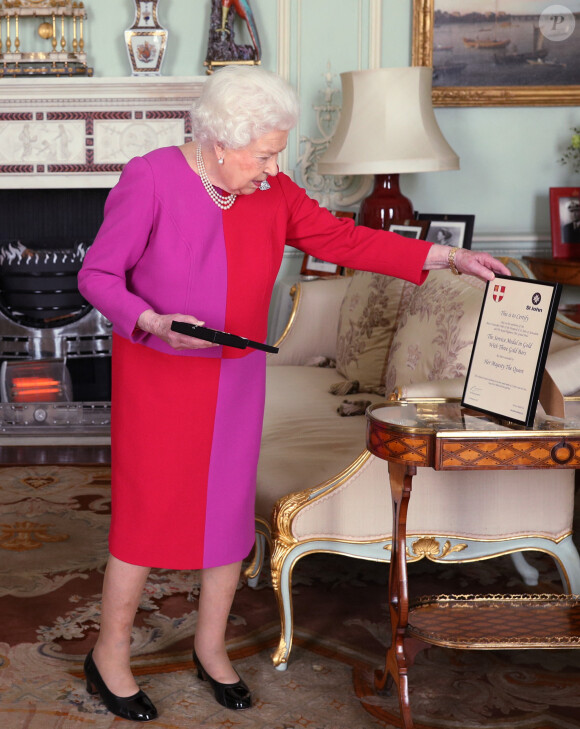 La reine Elizabeth II d'Angleterre se voit remettre la première Médaille d'Ordre en Or par le professeur Mark Compton lors d'une audience au palais de Buckingham à Londres. Le 11 mars 2020