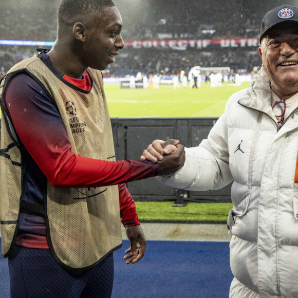 Le réalisateur Fabien Onteniente a filmé pendant le match de Ligue 1 Uber Eats "PSG-Rennes" (1-1) au Parc des Princes à Paris, quelques séquences de son prochain film, qui s'intitulera " 4 Zéros " avec l'acteur Mamadou Haïdara le 25 février 2024. Il n'est pas venu en simple spectateur, mais avec deux caméras. Fabien Onteniente a assisté à la rencontre entre le PSG et Rennes au Parc des Princes (Paris XVIe) pour tourner les toutes premières images de sa prochaine comédie, " 4 Zéros ". Prévu en salles pour 2025, ce long-métrage est la suite de " 3 Zéros ", qui avait attiré 1,2 million de spectateurs en 2002. Le réalisateur de 65 ans était au Parc pour filmer l'un de ses comédiens, Mamadou Haïdara, sortant du couloir qui donne sur la pelouse, puis s'échauffant avec, en arrière-plan donc, les vrais joueurs du PSG en train de disputer leur rencontre. Treizième film de Fabien Onteniente (après " Camping ", " Disco ", " Turf "...), " 4 Zéros " racontera l'histoire de Kidane, un jeune Comorien qui a quitté sa famille pour traverser la Méditerranée. Repéré lors du défi de la " Lucarne d'Évry " par Manu, un fils de restaurateurs en galère qui espère découvrir le nouveau Mbappé, Kidane va vite être convoité par d'autres recruteurs... " C'est la success story d'un gamin qui rêve de devenir une star du PSG ", explique Fabien Onteniente, qui a cosigné son scénario avec A. Fourlon, le coscénariste de " Chasse gardée ". S. Bugsy, D. Bourdon et... G. Roux Comme l'a révélé le site d'information Satellifacts, on trouvera au casting de " 4 Zéros " I. Nanty, G. Lanvin ou le rappeur .Bugsy (qui jouaient déjà dans " 3 Zéros "), mais aussi D.Bourdon, Shy'm, Kaaris, Pa. Deby et JC Darmon. De nombreux invités sont annoncés, comme les anciens entraîneurs Rolland Courbis et Guy Roux. Les footballeurs David Ginola, O. Giroud et P. Kimpembe feront aussi des apparitions. Le rôle principal, celui de Kidane, sera tenu par Mamadou Haïdara, 19 ans, qui incarne la version jeune du personnage joué par O. Sy dans " Lupin " sur Netflix. Fabien Onteniente poursuivra ensuite le tournage de sa comédie à partir du 4 mars entre Paris et Reims. Grâce à un partenariat avec le PSG, il pourra poser ses caméras dans les installations du Parc des Princes et dans le centre d'entraînement du PSG à Poissy (Yvelines). Abonné au PSG depuis 1974, le cinéaste, qui a grandi à Paris, est un immense fan du club de la capitale. Lui-même a beaucoup joué au foot dans sa jeunesse. " C'était le seul sport que tu pouvais faire sans avoir d'argent, avec un ballon pour 22 ! ", sourit-il. © Cyril Moreau/Bestimage