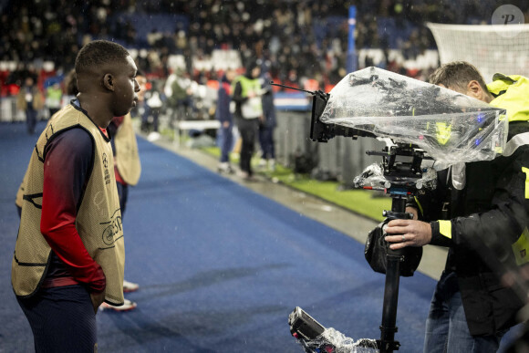 Le réalisateur Fabien Onteniente a filmé pendant le match de Ligue 1 Uber Eats "PSG-Rennes" (1-1) au Parc des Princes à Paris, quelques séquences de son prochain film, qui s'intitulera " 4 Zéros " avec l'acteur Mamadou Haïdara le 25 février 2024. Il n'est pas venu en simple spectateur, mais avec deux caméras. Fabien Onteniente a assisté à la rencontre entre le PSG et Rennes au Parc des Princes (Paris XVIe) pour tourner les toutes premières images de sa prochaine comédie, " 4 Zéros ". Prévu en salles pour 2025, ce long-métrage est la suite de " 3 Zéros ", qui avait attiré 1,2 million de spectateurs en 2002. Le réalisateur de 65 ans était au Parc pour filmer l'un de ses comédiens, Mamadou Haïdara, sortant du couloir qui donne sur la pelouse, puis s'échauffant avec, en arrière-plan donc, les vrais joueurs du PSG en train de disputer leur rencontre. Treizième film de Fabien Onteniente (après " Camping ", " Disco ", " Turf "...), " 4 Zéros " racontera l'histoire de Kidane, un jeune Comorien qui a quitté sa famille pour traverser la Méditerranée. Repéré lors du défi de la " Lucarne d'Évry " par Manu, un fils de restaurateurs en galère qui espère découvrir le nouveau Mbappé, Kidane va vite être convoité par d'autres recruteurs... " C'est la success story d'un gamin qui rêve de devenir une star du PSG ", explique Fabien Onteniente, qui a cosigné son scénario avec A. Fourlon, le coscénariste de " Chasse gardée ". S. Bugsy, D. Bourdon et... G. Roux Comme l'a révélé le site d'information Satellifacts, on trouvera au casting de " 4 Zéros " I. Nanty, G. Lanvin ou le rappeur .Bugsy (qui jouaient déjà dans " 3 Zéros "), mais aussi D.Bourdon, Shy'm, Kaaris, Pa. Deby et JC Darmon. De nombreux invités sont annoncés, comme les anciens entraîneurs Rolland Courbis et Guy Roux. Les footballeurs David Ginola, O. Giroud et P. Kimpembe feront aussi des apparitions. Le rôle principal, celui de Kidane, sera tenu par Mamadou Haïdara, 19 ans, qui incarne la version jeune du personnage joué par O. Sy dans " Lupin " sur Netflix. Fabien Onteniente poursuivra ensuite le tournage de sa comédie à partir du 4 mars entre Paris et Reims. Grâce à un partenariat avec le PSG, il pourra poser ses caméras dans les installations du Parc des Princes et dans le centre d'entraînement du PSG à Poissy (Yvelines). Abonné au PSG depuis 1974, le cinéaste, qui a grandi à Paris, est un immense fan du club de la capitale. Lui-même a beaucoup joué au foot dans sa jeunesse. " C'était le seul sport que tu pouvais faire sans avoir d'argent, avec un ballon pour 22 ! ", sourit-il. © Cyril Moreau/Bestimage