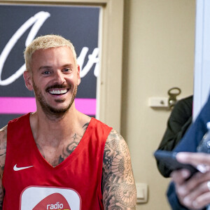 Matt Pokora (M.Pokora) s'échauffe avant de rentrer sur le terrain. Tony Parker et Matt Pokora (M.Pokora) s'affrontent lors d'un match de basket par équipes dans le cadre d'une animation Radio Scoop au Gymnase Mado Bonnet à Lyon le 26 octobre 2023. 