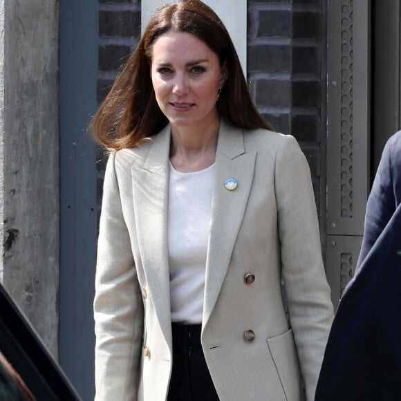 Le prince William, duc de Cambridge, et Catherine (Kate) Middleton, duchesse de Cambridge, visitent le comité d'urgence de Londres, à la rencontre de bénévoles de retour de leur mission humanitaire en Ukraine, le 21 avril 2022. En guise de soutien, le couple princier porte un badge aux couleurs du drapeau ukrainien. 