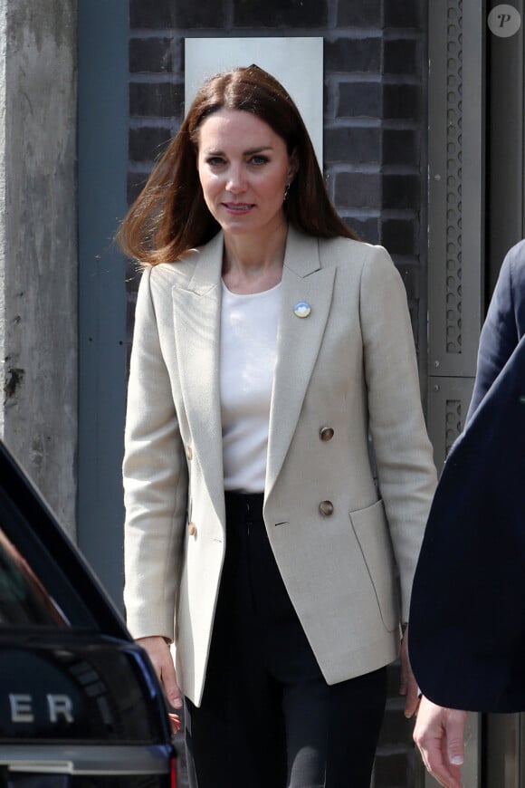 Le prince William, duc de Cambridge, et Catherine (Kate) Middleton, duchesse de Cambridge, visitent le comité d'urgence de Londres, à la rencontre de bénévoles de retour de leur mission humanitaire en Ukraine, le 21 avril 2022. En guise de soutien, le couple princier porte un badge aux couleurs du drapeau ukrainien. 