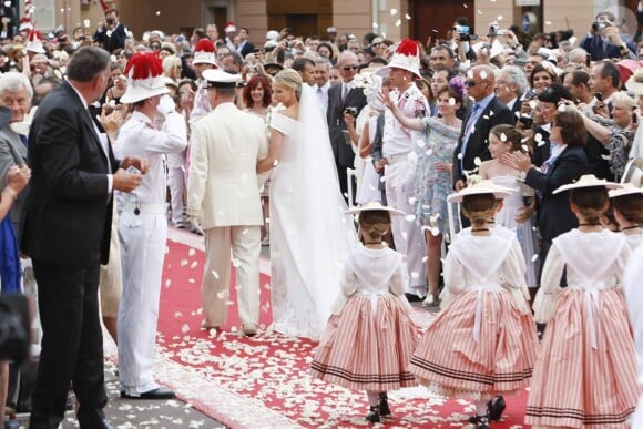 La date a donc changé, mais ils ont pu à l'arrivée se dire "oui".
Le prince Albert de Monaco et la princesse Charlene, unis devant Dieu par Mgr. Barsi, ressortent de la cour d'honneur du palais princier sous les vivats et les pétales, samedi 2 juillet 2011.