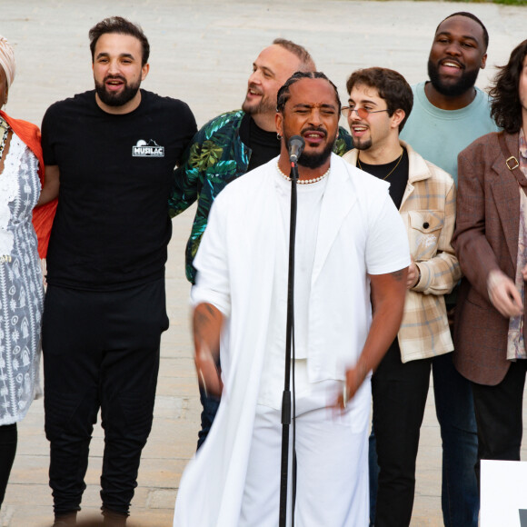 Exclusif - Slimane interprète sa nouvelle chanson "Résister" sur le parvis de Notre-Dame à Paris. Le 6 juin 2024. A quelques jours de la sortie de ce nouveau single, le chanteur a fait un happening étonnant hier soir à 20h30 entouré de 30 choristes. Ces images tournées intégreront le clip qui, lui aussi, sortira prochainement. © Christophe Clovis / Bestimage 