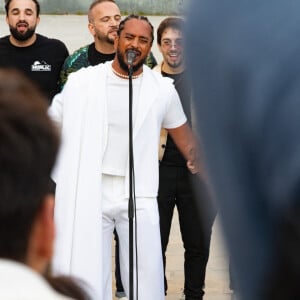 Exclusif - Slimane interprète sa nouvelle chanson "Résister" sur le parvis de Notre-Dame à Paris. Le 6 juin 2024. A quelques jours de la sortie de ce nouveau single, le chanteur a fait un happening étonnant hier soir à 20h30 entouré de 30 choristes. Ces images tournées intégreront le clip qui, lui aussi, sortira prochainement. © Christophe Clovis / Bestimage 