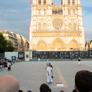 Exclusif - Slimane interprète sa nouvelle chanson "Résister" sur le parvis de Notre-Dame à Paris. Le 6 juin 2024. A quelques jours de la sortie de ce nouveau single, le chanteur a fait un happening étonnant hier soir à 20h30 entouré de 30 choristes. Ces images tournées intégreront le clip qui, lui aussi, sortira prochainement. © Christophe Clovis / Bestimage 