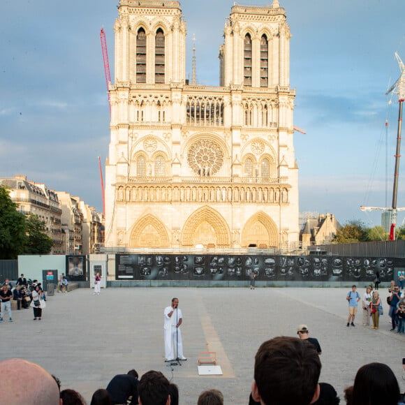 Exclusif - Slimane interprète sa nouvelle chanson "Résister" sur le parvis de Notre-Dame à Paris. Le 6 juin 2024. A quelques jours de la sortie de ce nouveau single, le chanteur a fait un happening étonnant hier soir à 20h30 entouré de 30 choristes. Ces images tournées intégreront le clip qui, lui aussi, sortira prochainement. © Christophe Clovis / Bestimage 