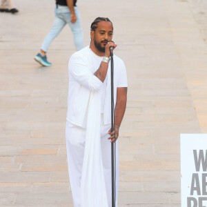 Exclusif - Slimane interprète sa nouvelle chanson "Résister" sur le parvis de Notre-Dame à Paris. Le 6 juin 2024. A quelques jours de la sortie de ce nouveau single, le chanteur a fait un happening étonnant hier soir à 20h30 entouré de 30 choristes. Ces images tournées intégreront le clip qui, lui aussi, sortira prochainement. © Christophe Clovis / Bestimage 