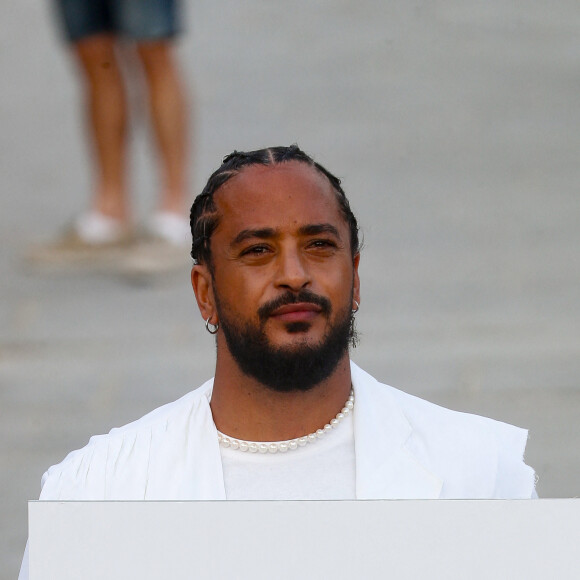 Exclusif - Slimane interprète sa nouvelle chanson "Résister" sur le parvis de Notre-Dame à Paris. Le 6 juin 2024. A quelques jours de la sortie de ce nouveau single, le chanteur a fait un happening étonnant hier soir à 20h30 entouré de 30 choristes. Ces images tournées intégreront le clip qui, lui aussi, sortira prochainement. © Christophe Clovis / Bestimage 