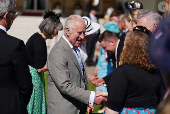 Le roi Charles III d'Angleterre et Camilla Parker Bowles, reine consort d'Angleterre, reçoivent des invités lors d'une Garden Party à Buckingham Palace à Londres, le 8 mai 2024.