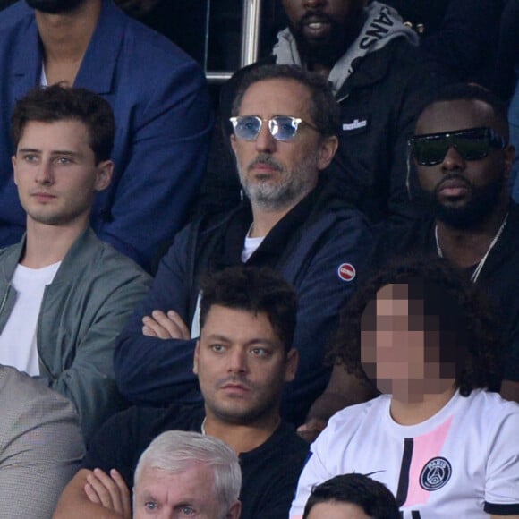 Gad Elmaleh avec son fils Noé, Gims (Maître Gims), Kev Adams et son frère Noam, Luis Fernandez - People en tribunes du match de football en ligue 1 Uber Eats : Le PSG (Paris Saint-Germain) remporte la victoire 2-1 contre Lyon au Parc des Princes à Paris le 19 septembre 2021. 