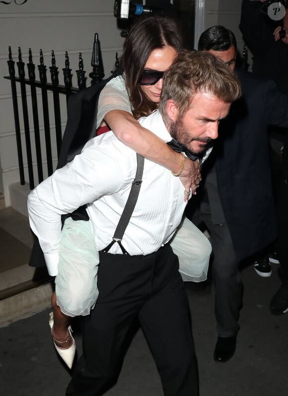 David Beckham porte sa femme Victoria Beckham sur son dos, à la sortie de la soirée de son 50ème anniversaire au club Oswald's à Londres, le 20 avril 2024. Arrivée munie de béquilles, Victoria Beckham a quitté sa fête d'anniversaire vers 2h30 du matin, portée par son mari depuis presque 25 ans.