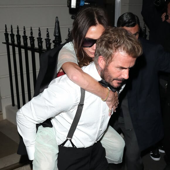 David Beckham porte sa femme Victoria Beckham sur son dos, à la sortie de la soirée de son 50ème anniversaire au club Oswald's à Londres, le 20 avril 2024. Arrivée munie de béquilles, Victoria Beckham a quitté sa fête d'anniversaire vers 2h30 du matin, portée par son mari depuis presque 25 ans.